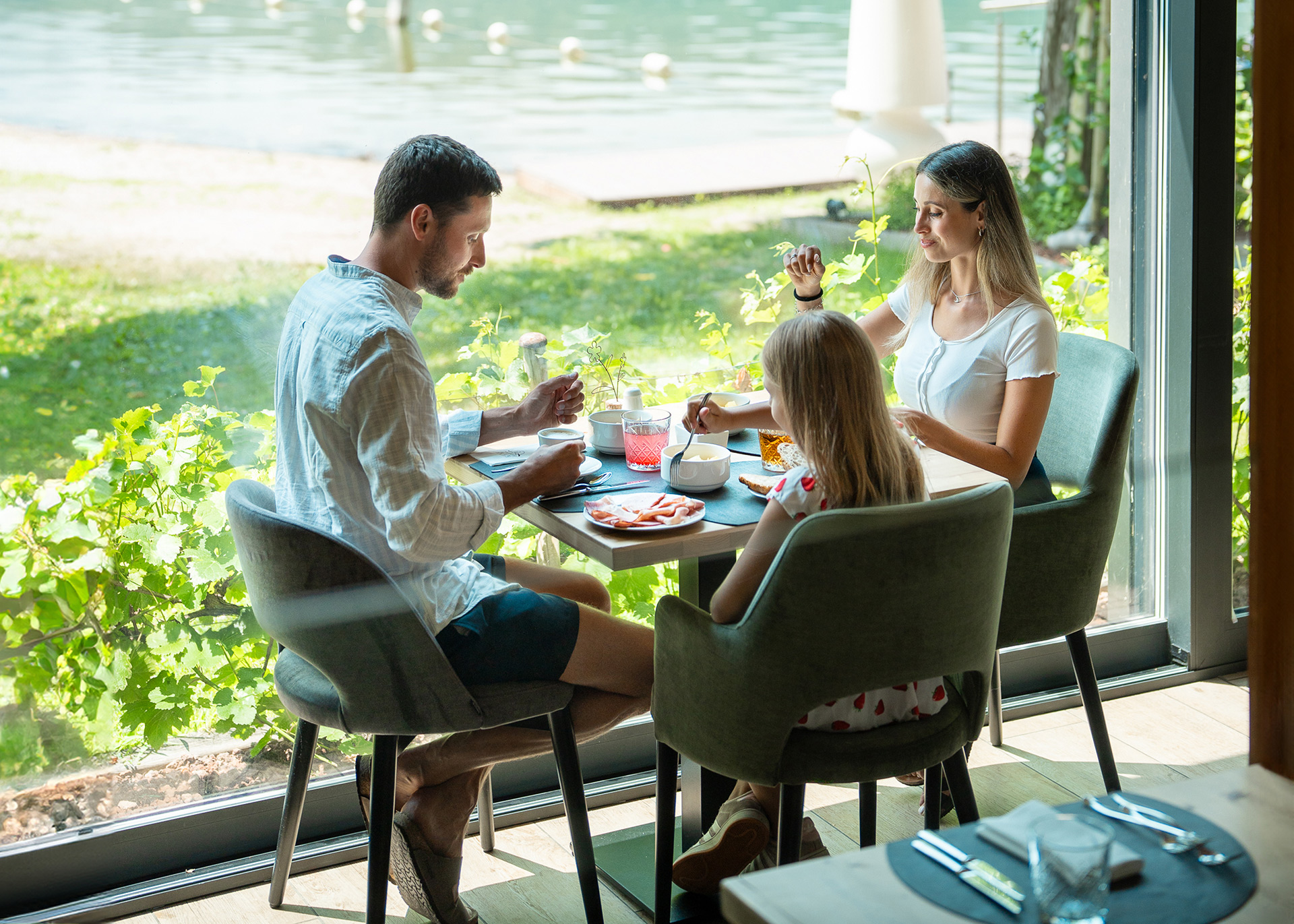 Famiglia che fa colazione in terrazza con vista lago